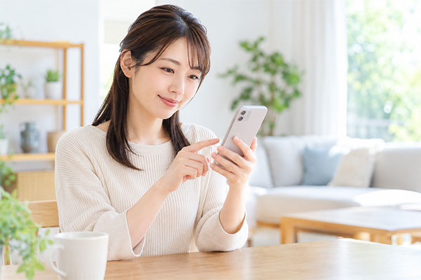 スマホでネット予約を行う女性
